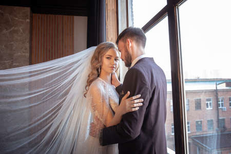 beautiful young couple. groom and bride. a modern wedding. dark interior.の写真素材
