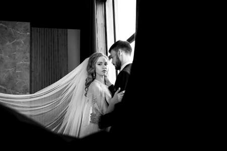 beautiful young couple. groom and bride. a modern wedding. dark interior.の写真素材