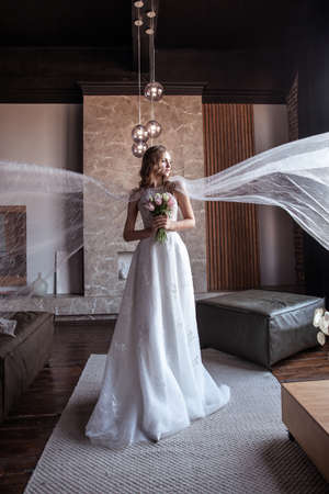 a lot of veil. bride in fancy dress. wedding dress with long arms. dark interiorの写真素材