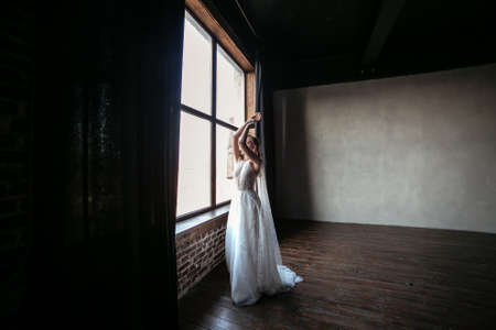 young and beautiful blonde bride in a dark interior.の写真素材