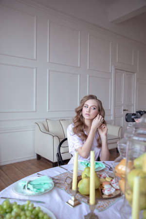 portrait of a beautiful young girl in a white robe in a bright interiorの写真素材