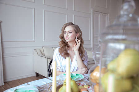 portrait of a beautiful young girl in a white robe in a bright interiorの写真素材