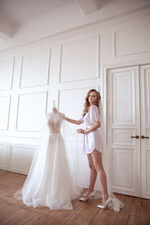 Wedding portrait in the morning at the hotel. girl in a white robe and veil. bride morningの写真素材