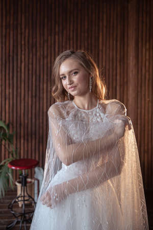 young and beautiful blonde bride in a dark interior.の写真素材