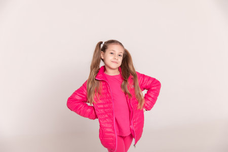 a girl with tails on a white background. baby in a pink jacket. copy spaceの写真素材