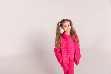 a girl with tails on a white background. baby in a pink jacket. copy spaceの写真素材