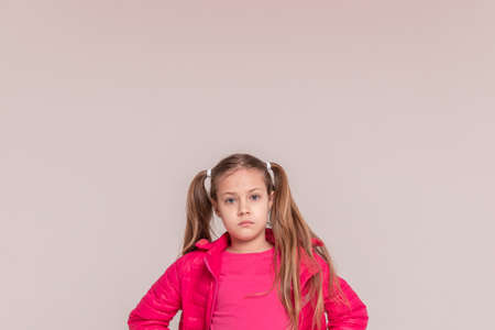 a girl with tails on a white background. baby in a pink jacket. copy spaceの写真素材