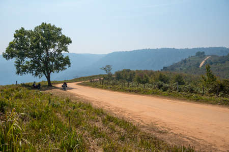 Motorcycles is park under shadow in dirt road.の写真素材