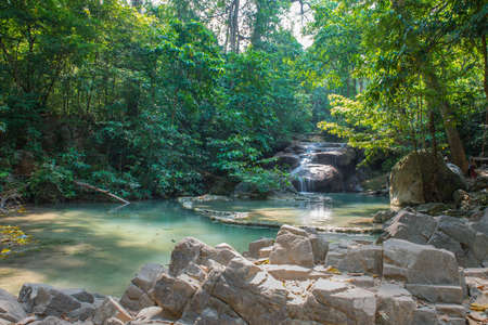 Water fall in the forest with blue water.の写真素材