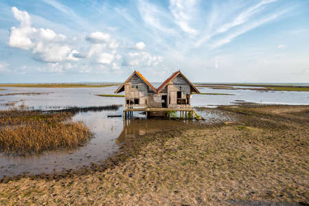 Waste double house alone on wet land.の写真素材