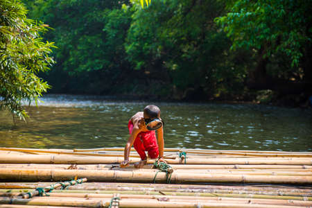 SAGKLABURI THAILAND- MARCH 11 : Unidentified boyl is fishing on the raft on March 11, 2016 at Songkhalia Creek.のeditorial素材