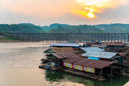 Under sunset, Mon Bridge of Sagklaburi, Thailand is a attracion. Tourists visit here for look at traditional lifestyle alongside river.のeditorial素材