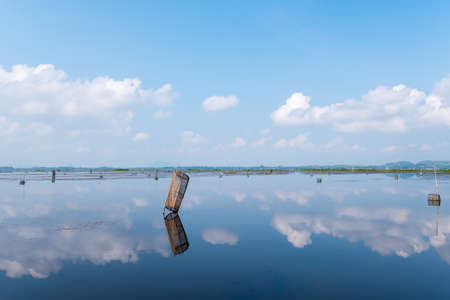 Tools for fishing under the reflect of cloud on the water.の写真素材