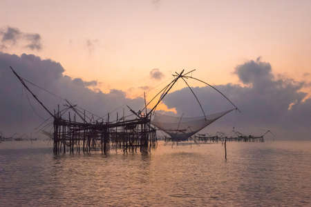 Silhouette the big fish net trap at dawn under romance sky.の写真素材
