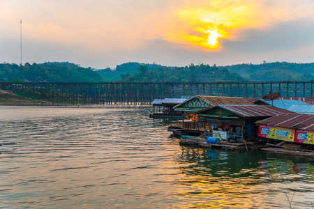 Under sunset, Mon Bridge of Sagklaburi, Thailand is a attracion. Tourists visit here for look at traditional lifestyle alongside river.のeditorial素材