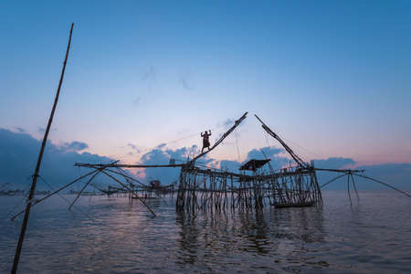 Khuan Khanun THAILAND- MARCH 25 : Unidentified fisherman stand on top of big fish net trap on March 25, 2016 at Thale noi.のeditorial素材