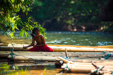 SAGKLABURI THAILAND- MARCH 11 : Unidentified boyl is fishing on the raft on March 11, 2016 at Songkhalia Creek.のeditorial素材