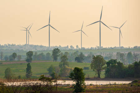 Warm tone in the sky and ground make you feel hot. The group of wind turbines is clean energy will make world to green again.の写真素材