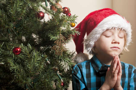 Sad boy praying at christmasの写真素材