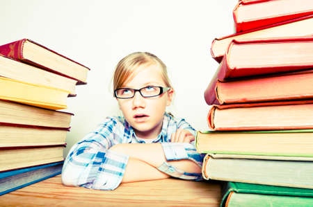 Bored kid with pile of books