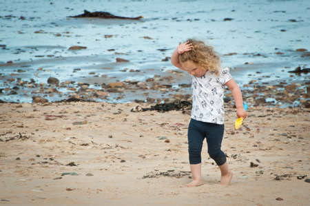 Little girl walking on a sandy beachの写真素材