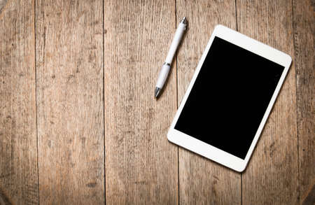 Modern tablet and pen seen from above againsta wooden textured background with ample copy spaceの写真素材