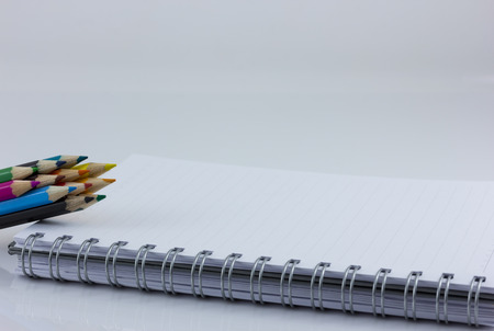 blank notebook isolated on white with color pencilの写真素材