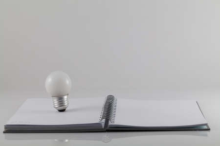 Notebook and bulbs isolate on white backgroundの写真素材