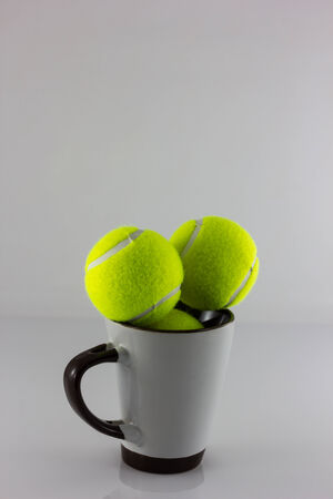 Tennis balls and Cofee cup isolate on white backgroundの写真素材