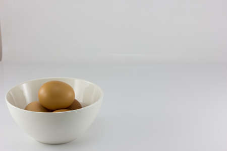 Eggs in white bowl isolate in white backgroundの写真素材