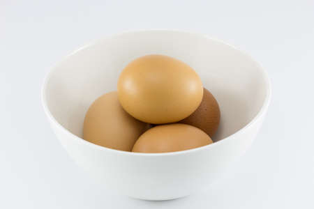 Eggs in white bowl isolate in white backgroundの写真素材