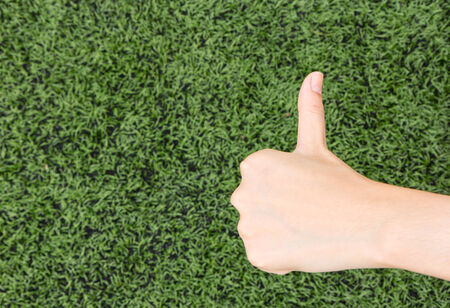Girl Thumbs on background lawn.の写真素材