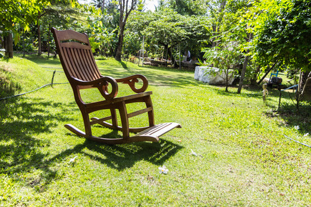 Empty rocking chair over grass at summer sunsetの写真素材
