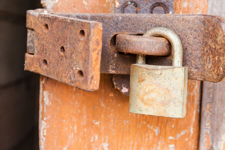 Old rusty padlock on a wooden doorの写真素材