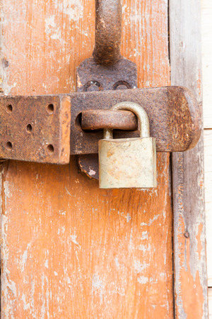 Old rusty padlock on a wooden doorの写真素材