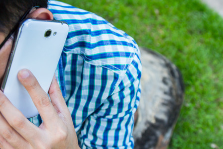Close up man using mobile smart phone green backgroundの写真素材