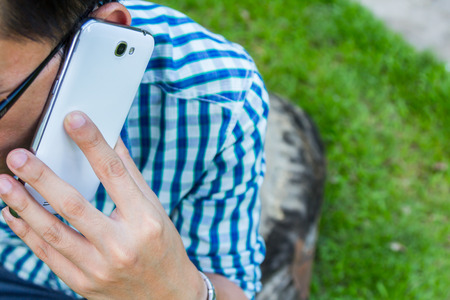 Close up man using mobile smart phone green backgroundの写真素材