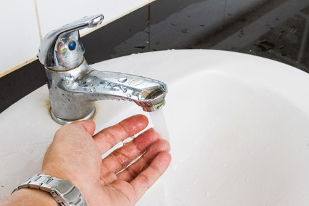 Washing hands in a public restroom, public sinksの写真素材