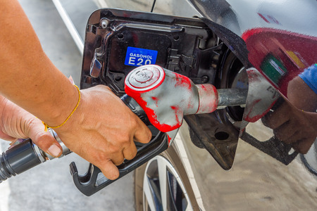 Men hold Fuel nozzle to add fuel in car at gas stationの写真素材