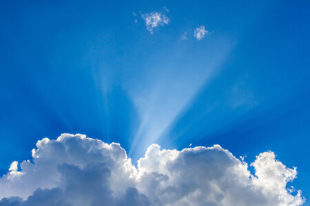 Sun peeking through the clouds backgroundの写真素材