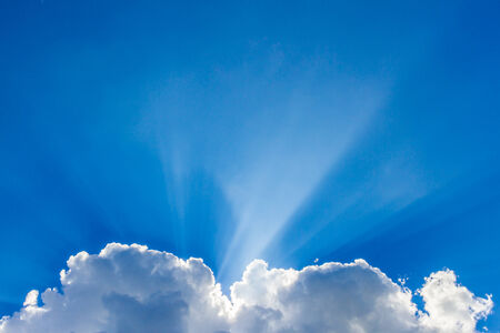 Sun peeking through the clouds backgroundの写真素材