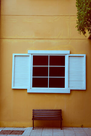Vintage window on yellow cement wallの写真素材