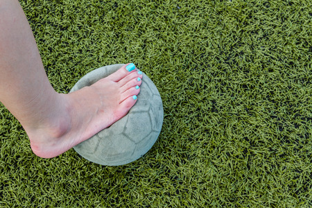 Girl Barefoot and old soccer ball backgroundの写真素材