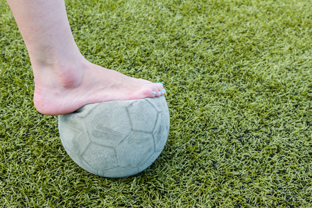 Girl Barefoot and old soccer ball backgroundの写真素材