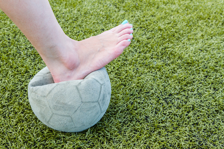 Girl Barefoot and old soccer ball backgroundの写真素材
