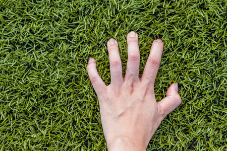 girl hand on soccer field grass backgroundの写真素材