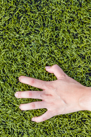 girl hand on soccer field grass backgroundの写真素材