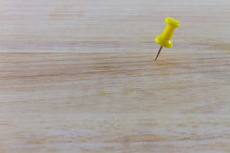 Yellow pin on the wood の写真素材