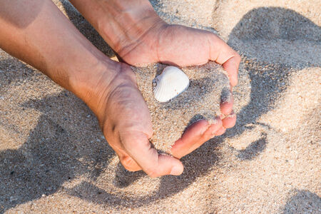Sea shells and sand in  hands background