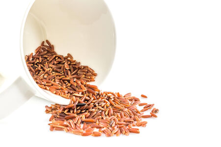 brown rice  close-up and cup on white backgroundの写真素材